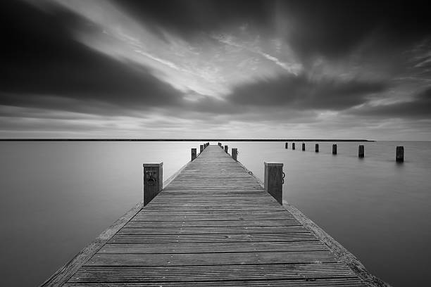 Jetty at lake Markermeer with a long exposure in black and white.